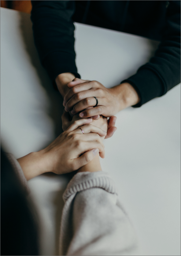 aerial shot of two people holding hands across a table